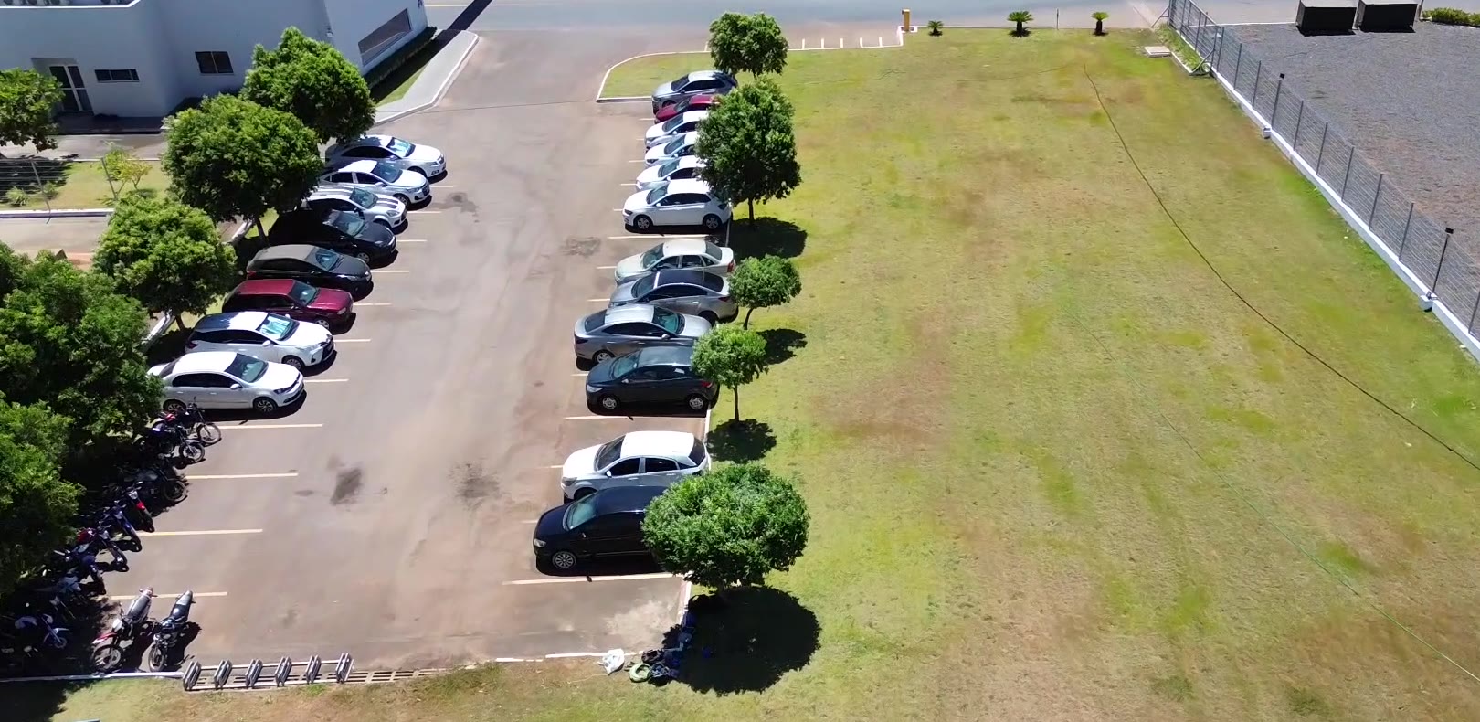 Vista aérea de gramado irrigado ao lado do estacionamento de uma empresa
