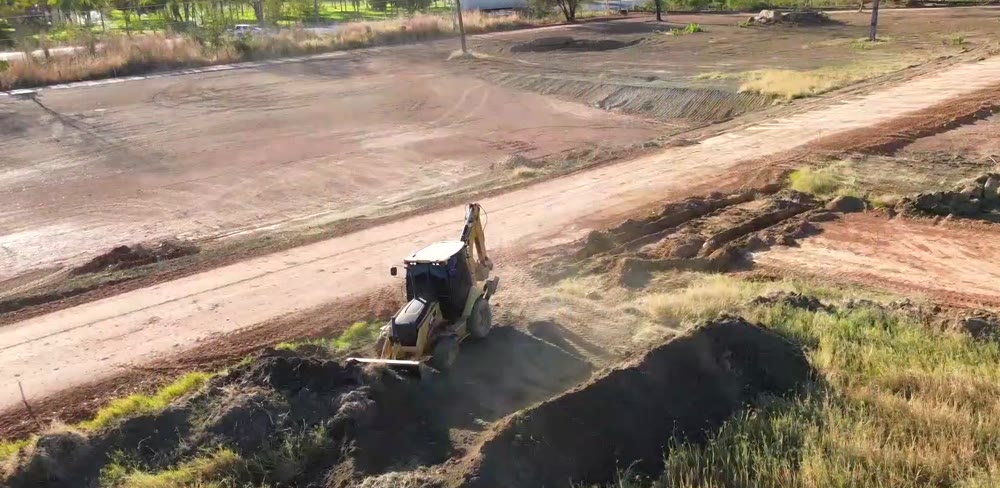 Retroescavadeira abrindo vala em área de obra